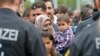 German policemen register refugees at the rail station in Freilassing, Germany, Monday, Sept. 14, 2015.