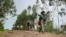 FILE - A militia fighter walks down a path as villagers flee with their belongings in the other direction, near the village of Chenna Teklehaymanot, in the Amhara region of northern Ethiopia, Sept. 9, 2021.