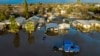 Casas y vehículos rodeados de una inundación tras varios días de lluvias en la población Planada del condado Merced, California, el martes 10 de enero de 2023. 