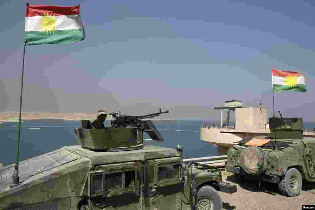 Peshmerga fighters in vehicles with Kurdish flags guard Mosul Dam, Aug. 21, 2014.