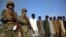 Pakistani paramilitary soldier stand guard next to suspects arrested during a search operation in Shah Kass, an area of Pakistani Khyber tribal region along Afghan border, March 3, 2017. 