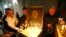 FILE - People place candles inside a church during a gathering to mark the anniversary of Soviet leader Joseph Stalin's death in his hometown of Gori, Georgia, March 5, 2017. 