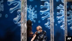 A man receives a coronavirus vaccine from medical staff at a COVID-19 vaccination center in Ramat Gan, Israel, Sunday, Jan. 3, 2021.