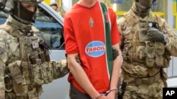 In this image, provided by the Ukrainian Intelligence Agency SBU on Monday, June 6, 2016, SBU agents detain a suspect at the Yahodyn border crossing on the Ukrainian-Polish border, Ukraine.