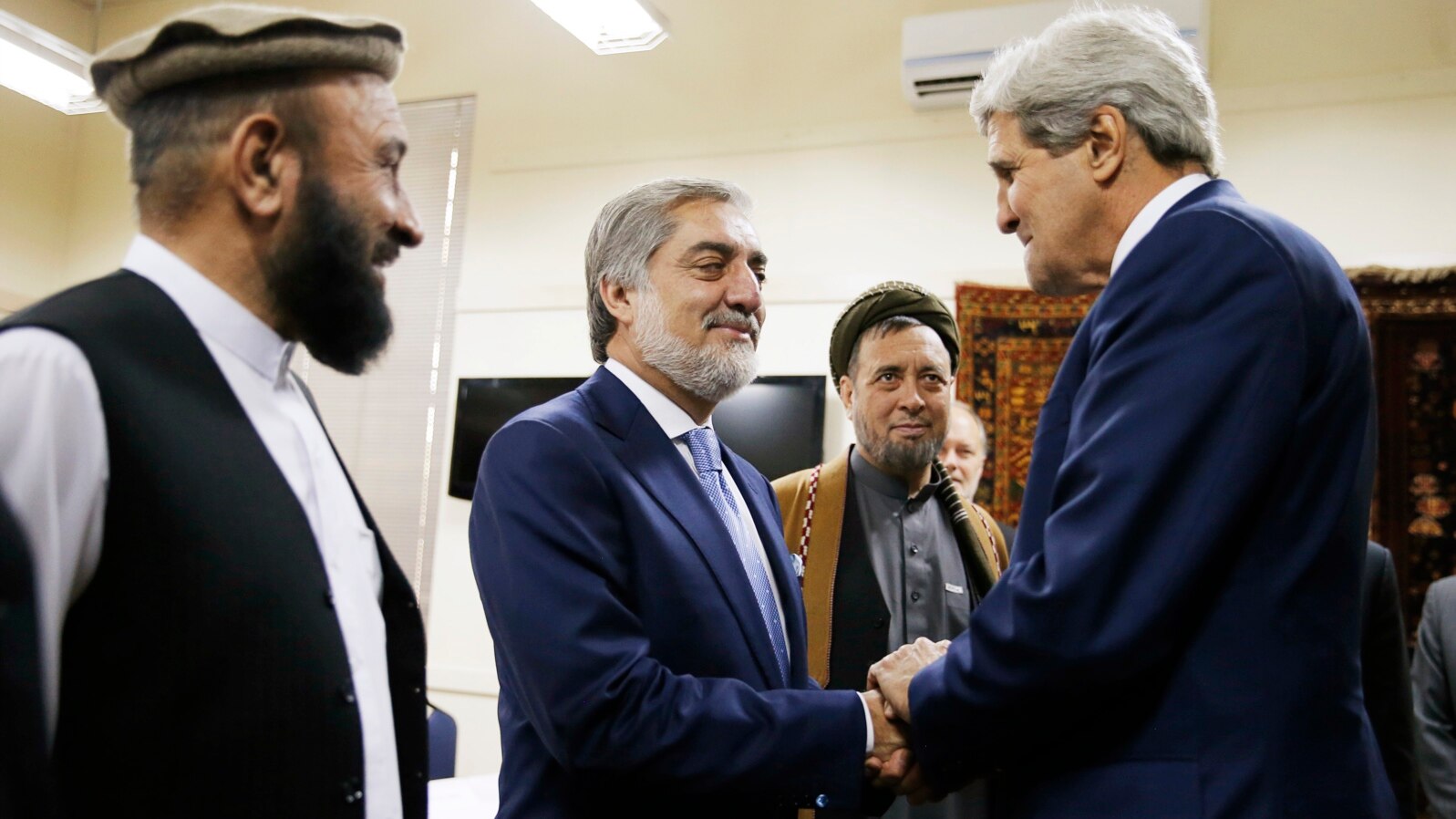 Afghan presidential candidate Abdullah Abdullah, center, shakes hands with U.S. Secretary of State John Kerry at the start of a meeting at the U.S. Embassy in Kabul, July 11, 2014.