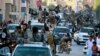 FILE - Fighters from the Islamic State group parade in Raqqa, north Syria, June 30, 2014.