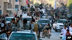 FILE - Fighters from the Islamic State group parade in Raqqa, north Syria, June 30, 2014.