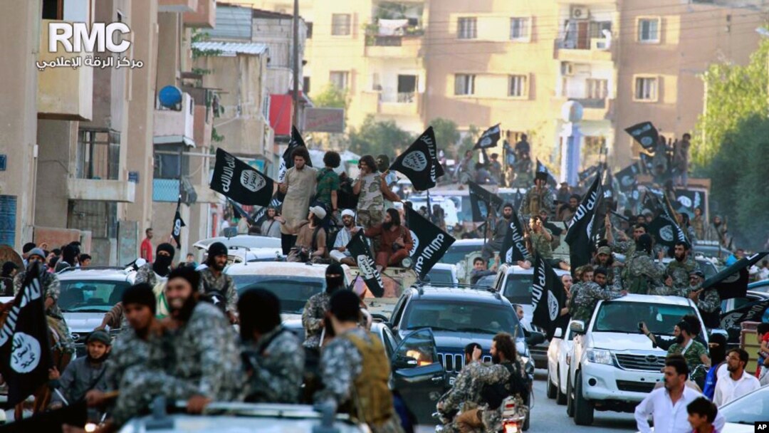 
Para kombatan kelompok teror ISIS berpawai di Raqqa, Suriah utara, 20 Juni 2014.
