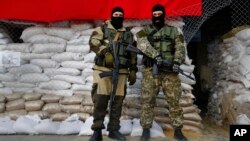 Armed pro-Russian men guard barricades in front of city hall in Slovyansk, eastern Ukraine, April 21, 2014.