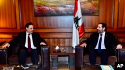 In this photo released by Lebanon's official government photographer Dalati Nohra, newly assigned Lebanese Prime Minister, Hassan Diab, left, meets with outgoing Prime Minister Saad Hariri, in Beirut, Dec. 21, 2019. 