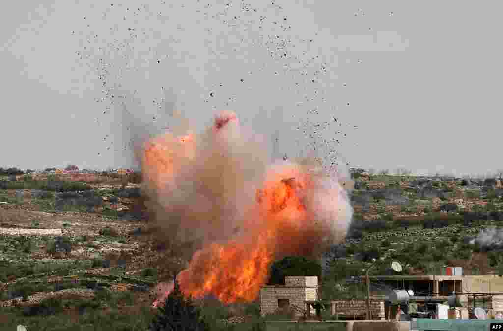 An explosion is seen following Russian airstrikes on the village of al-Bara in the southern part of Syria&#39;s northwestern Idlib province.