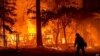Un bombero pasa junto a una casa en llamas mientras el incendio Dixie avanza por el condado de Plumas, California, el 24 de julio de 2021.