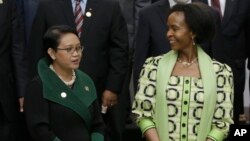 Indonesian Foreign Minister Retno Marsudi, left, talks with her South African counterpart Maite Nkoana-Mashabane as they prepare for a group photo prior to the opening session of the Asian African Ministerial Meeting in Jakarta, Indonesia, April 20, 2015.