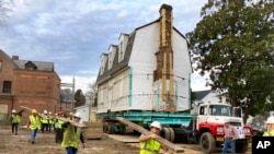 FILE - Workers prepare to move the original structure that held what is believed to be the oldest schoolhouse in the U.S. for Black children in Williamsburg, Virginia, Feb. 10, 2023.