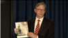 U.S. Special Representative for Iran Brian Hook speaks at a Sept. 28, 2018, press briefing in New York, holding a copy of the State Department's Sept. 25 report "Outlaw Regime: A Chronicle of Iran's Destructive Activities." 