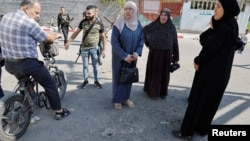 Local residents inspect an impact crater at the site of an Israeli drone strike that killed three Palestinians, on the day of their funeral at Jenin refugee camp in the Israeli-occupied West Bank Oct. 25, 2023. 