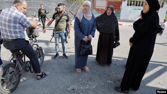 Local residents inspect an impact crater at the site of an Israeli drone strike that killed three Palestinians, on the day of their funeral at Jenin refugee camp in the Israeli-occupied West Bank Oct. 25, 2023. 