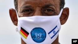 German Lieutenant colonel Samuel Mbassa wears a face mask with the flags of Israel and Germany at the airbase in Noervenich, Germany, Aug. 20, 2020. 
