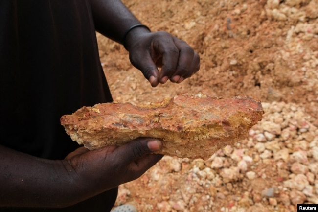 An illegal artisanal miner inspects an excavated rock for traces of gold at the Prestea-Huni Valley Municipal District in the Western Region, Ghana August 17, 2024. (REUTERS/Francis Kokoroko)