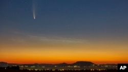 The Comet Neowise or C/2020 F3 is seen before sunrise over Balatonmariafurdo, Hungary, Tuesday, July 14, 2020. It passed closest to the Sun on July 3, and its closest approach to Earth will occur on July 23. (Gyorgy Varga/MTI via AP)