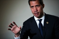 FILE - Juan Guaido, leader of Venezuela's political opposition, talks to a journalist during an interview with Associated Press in Brussels, Jan. 22, 2020.