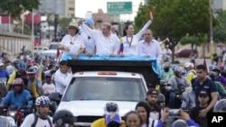 El candidato presidencial opositor Edmundo González Urrutia y la dirigente María Corina Machado saludan a la gente en camino a su último mitin de campaña en Maracaibo, capital del estado venezolano de Zulia, el martes 23 de julio.