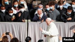 Pope Francis greets faithful as he arrives for the weekly general audience while coronavirus restrictions are eased at the Vatican, May 12, 2021. 