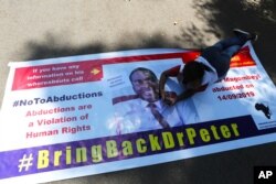 A Zimbabwean doctor lays on a banner during a protest in Harare, Sept, 18, 2019.