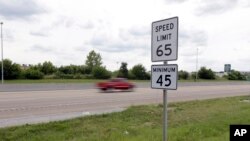 Un vehículo pasa una señal de límite de velocidad a lo largo de la Interestatal 64, en O'Fallon, Illinois. 