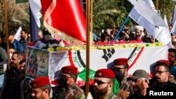 FILE - People carry the coffin of an Iraqi Kataib Hezbollah fighter, who was killed in a U.S. airstrike in Babil Province, during the funeral in Baghdad, Iraq, December 26, 2023.