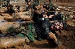 FILE - Members of the Kurdish peshmerga special forces demonstrate their skills during their graduation ceremony at a military camp in Soran district, in Irbil province, Iraq, Feb. 12, 2020.