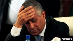 FILE - Libya's Prime Minister Ali Zeidan places his hand on his forehead as he addresses a news conference after his release and arrival at the headquarters of the Prime Minister's Office in Tripoli, Oct. 10, 2013.