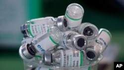 Empty vials of China's Sinopharm vaccine sit in a cup during a priority COVID-19 vaccination campaign of health workers at a public hospital in Lima, Peru, Feb. 10, 2021.