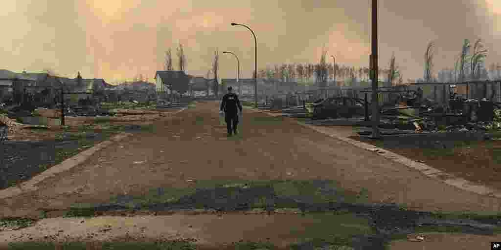 Un gendarme inspecte les dégâts dans la rue de Fort McMurray, à Alberta, le 4 mai 2016.