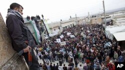 A member of the Free Syrian Army stands guard as anti-Syrian regime protesters hold a demonstration in Idlib, Syria, Feb. 6, 2012.