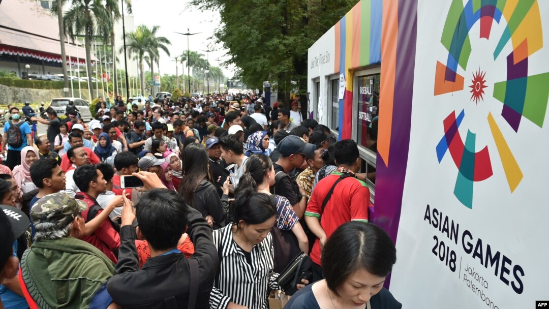 Antrean calon penonton yang ingin membeli tiket mengular di depan kios-kios penjualan di luar kompleks olahraga Senayan, Jakarta, 21 Agustus 2018.