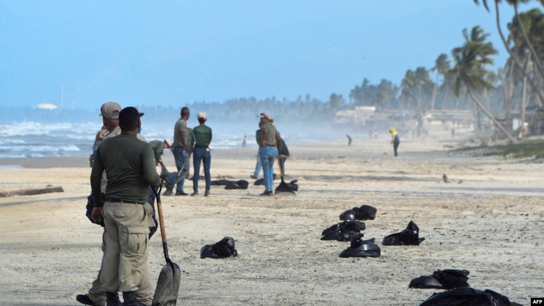 Miembros del Instituto de Parques Nacionales (INPARQUES) recolectan residuos de petróleo en la playa Boca de Yaracuy en el estado Falcón, Venezuela, el 19 de agosto de 2024.