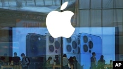 资料照片：人们在北京的一家Apple商店试用iPhone产品。