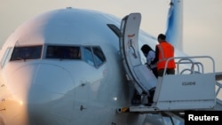 A Venezuelan migrant is escorted to board a repatriation flight as a part of an immigration enforcement process, at the Valley International Airport, in Harlingen, Texas, Oct. 18, 2023. 