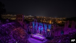 Spectators listen a concert at Odeon of Herodes Atticus as the city of Athens is seen on the background, July 15, 2020.