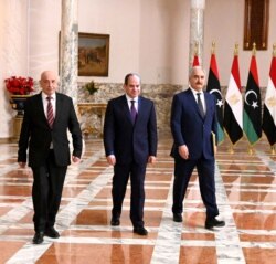 FILE - A handout picture released by the Egyptian Presidency June 6, 2020, shows Egyptian President Abdel Fattah el-Sissi (C), Libyan commander Khalifa Haftar (R) and Libyan Parliament speaker Aguila Saleh arriving for a press conference in Cairo.