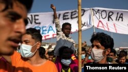 12일 그리스 레스보스섬의 전소된 모르아 난민캠프 인근에서 난민들이 시위를 벌이고 있다. 