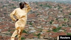 In this file photo, Yinka Sotomi stands atop Oluma Rock, a spiritual site for the Yoruba tribe, overlooking the city of Abeokuta in southern Nigeria, April 16, 2007. (REUTERS/Finbarr O'Reilly)