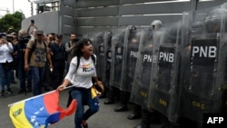 FILE - Opposition supporters confront Venezuelan security forces at the National Assembly in Caracas, Venezuela, March 10, 2020. 
