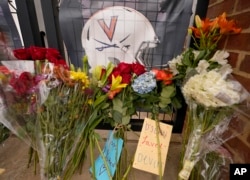 FILE - Memorial flowers and notes line walkway at Scott Stadium after three football players were killed in a shooting on the grounds of the University of Virginia on Nov. 15, 2022. (AP Photo/Steve Helber)