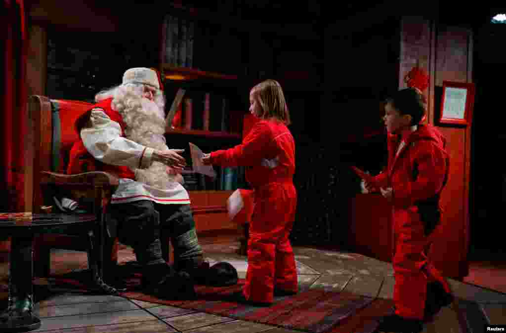 Everyday, Santa is busy meeting children around the world coming to see him. In this picture, he talks to Eloise and Noah Seymour from England at Santa Claus&#39; Village.