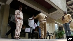 Police and forensic officials outside Bollywood actor Saif Ali Khan's residential building after he was operated for stab injuries following a scuffle with an intruder at his home in Mumbai, Jan. 16, 2025.