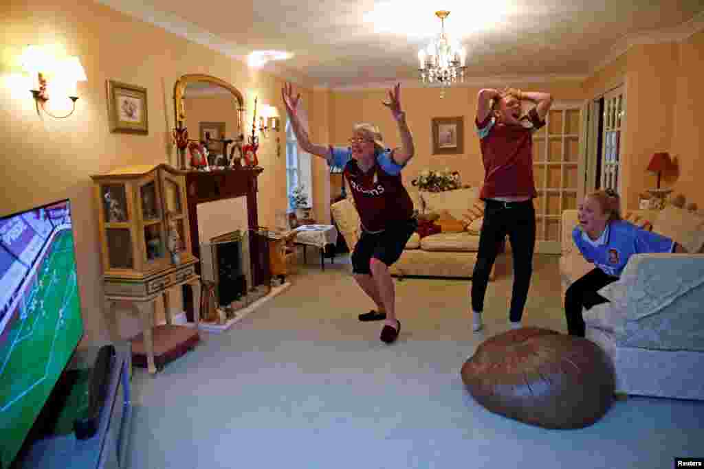 Aston Villa fans Martin, Harry and Lucy Chrispin watch the game on TV at home near Amersham, as the game resumes behind closed doors following the outbreak of the coronavirus disease (COVID-19).