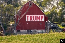FILE - Corn grows in front of a barn displaying a large Trump sign in rural Ashland, Nebraska, July 24, 2018.