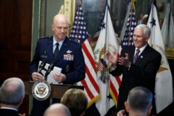 Vice President Mike Pence, right, applauds during swearing in ceremony for Air Force General John Raymond as Chief of Space Operations, in his Ceremonial Office in the White House complex, Jan. 14, 2020 in Washington.